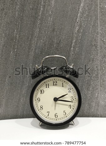 Retro alarm clock on gray tile background.