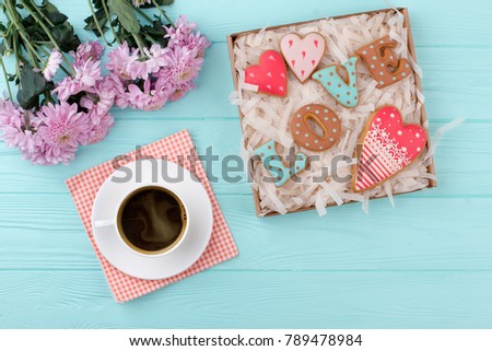 Valentines Day love cookies in gift box. Cup of black coffee, cookies and flowers on wooden background. Good morning and happy Valentines Day. Valentines Day background.