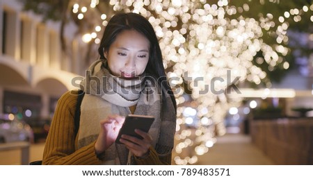 Woman use of smart phone in the winter time at night 