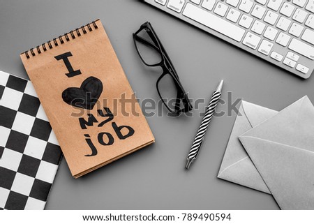 Find dream job. Handwritten motto I love my job in notebook on office desk on grey background top view