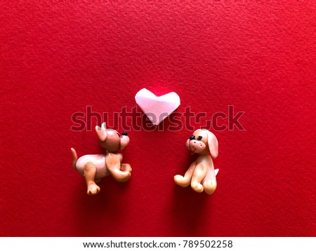 Love, Valentine, Puppy love, Relationship concept. Dog miniature, pink origami heart on red paper texture background. Copy space for text. 