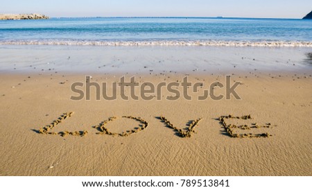 Word love written on the seashore in the sand of a beautiful beach