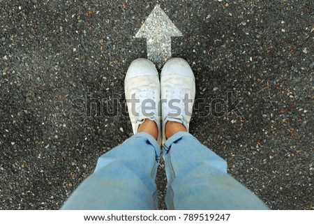 Selfie White Shoes Concept. Female Wearing White Sneakers with White Arrows Line Direction on Concrete Road Background Great for Any Use.