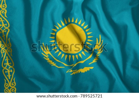 The Kazakh flag flutters in the wind. Colorful, national flag of Kazakhstan. Patriotism, a patriotic symbol.