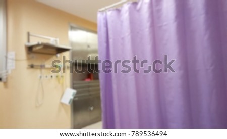 Blurred abstract background of hospital interior inside ICU ward with doctor working on monitoring, reading patient's health on medical equipment/ instrument in front of intensive care unit room.