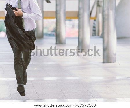 Stressed anxious businessman in a hurry and running, he is late for his business appointment and Wear a shirt while running. Royalty-Free Stock Photo #789577183