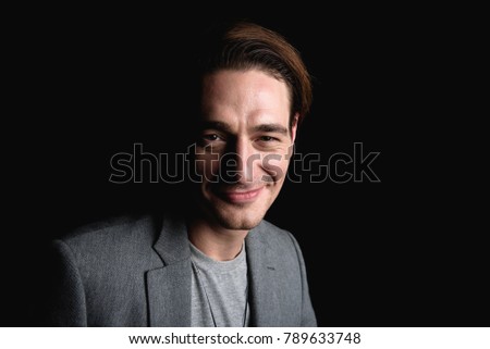 Great day. Portrait of positive pleasant young man is standing and looking at camera with joy while feeling happiness. Isolated background with copy space in the right side