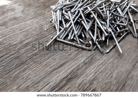 pile of metal nails isolate on wood. A lot of metal nails.