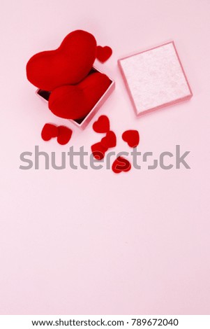 Valentines day background. Feminine desk workspace with gift box and red heart on pink background with copy space. Flat lay. Top view.
