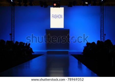 podium before showing new collection of clothing, dark silhouettes of audience