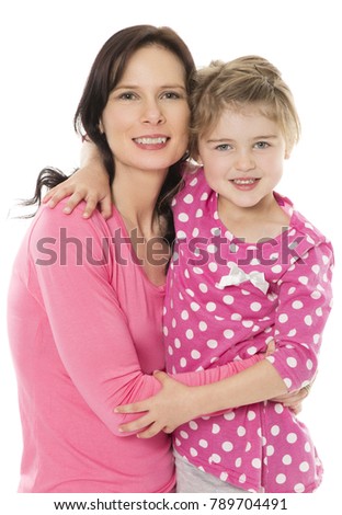 Adorable young blonde caucasian girl wearing a pink and white polkadot dress. The girl is with her mother.