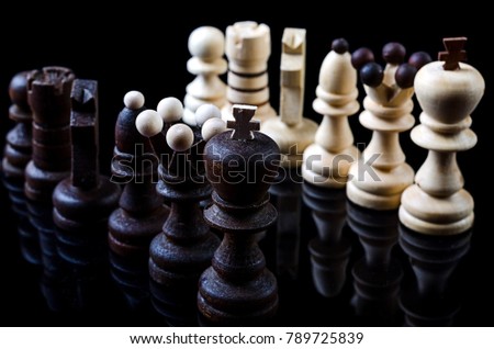 Chess pieces isolated on a black background. Black and white chess, background. Strategy of successful business.