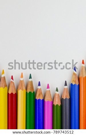 Colour pencils rainbow style, multicoloured pencils on white background. Close up. Selective focus.
