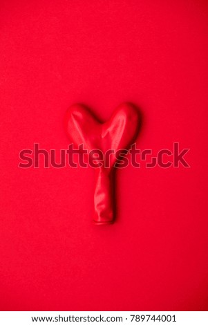 Red heart shaped balloon on a red background
