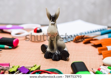 Back to School and Education concept. Toy donkeys surrounded with school supplies. school border with copy space