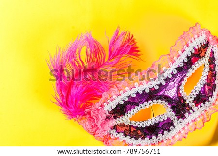 Mardi gras background with holiday mask, on bright yellow background copy space top view