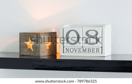 White block calendar present date 8 and month November on white wall background