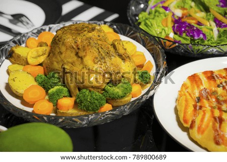 Picture of roast chicken with salad and pizza serving on the dining table