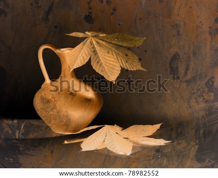 Still life with pitcher and leaves