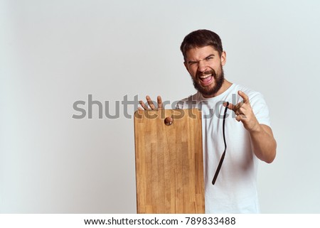  man with a shovel for cooking and a cutting board on a light background                              