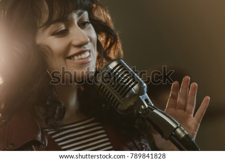 attractive young female singer performing song and smiling