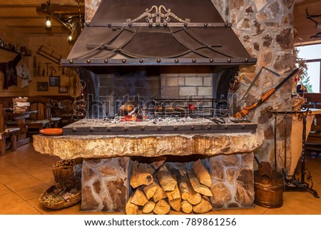 A stone brazier with iron forging in a restaurant with an unusual interior. Stone brazier