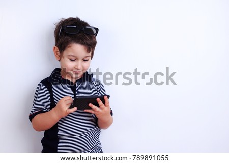 Little boy using mobile phone. Child playing on smartphone. Technology, mobile apps, children and parental advisory, lifestyle concept