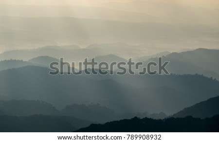 Take pictures of the mountain peaks in the morning of the new day. Mountains are foggy and sunny in the morning.