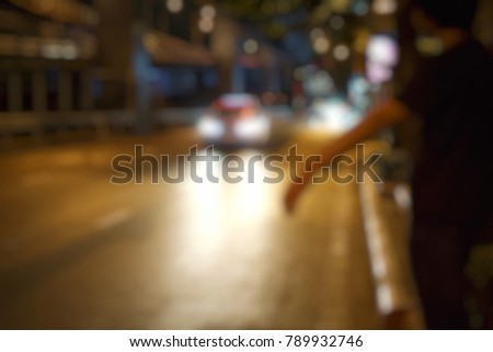 A man use and swing a hand to call a taxi in night time in Thailand.