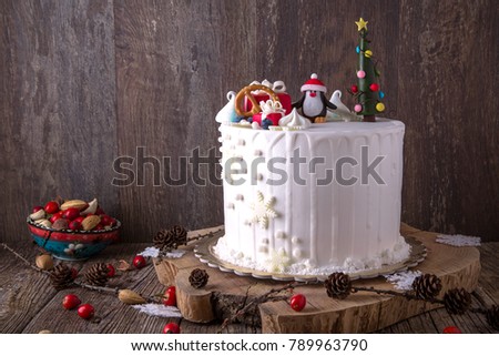 New Year's cake. A birthday cake for those born in winter. Snow cake decorated with penguin, Christmas trees and gifts