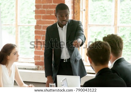Rude impolite african businessman pointing finger at colleague on team meeting, angry black boss scolding white employee for bad work, multiracial conflict at workplace, obnoxious behavior in office Royalty-Free Stock Photo #790043122