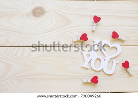 I love you inscription and pins with hearts on a light wooden background, top view. Concept of St.Valentine's Day, anniversary, wedding