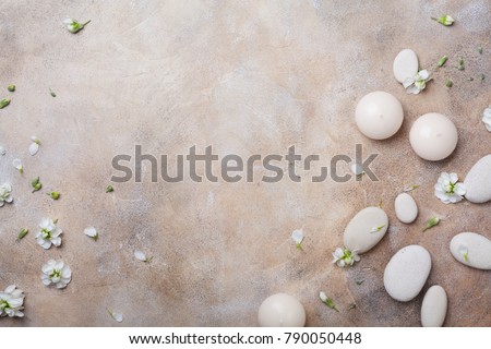 Aromatherapy, beauty and spa background with massage pebble and candles decorated with white flowers. Relaxation and zen like concept. Top view