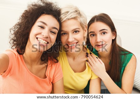 Happy friends or teenage girls taking selfie at home, enjoing time together