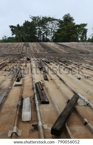 View of an old long roof of an house in Gabon. Abstract picture of steel used sheets. Brown colours of the surface and leading lines compose the design of this image. 
