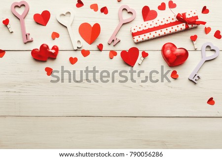 Valentine background with red paper hearts, love keys, giftbox and handmade soap bars on white rustic wooden planks closeup. Happy lovers day card mockup, copy space, top view