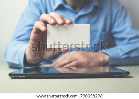Businessman showing a business card in his business desk.