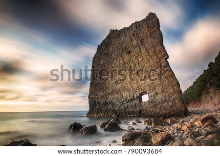 Vertical cliff with hole inside named Skala Parus on the coast of Black Sea. Royalty-Free Stock Photo #790093684