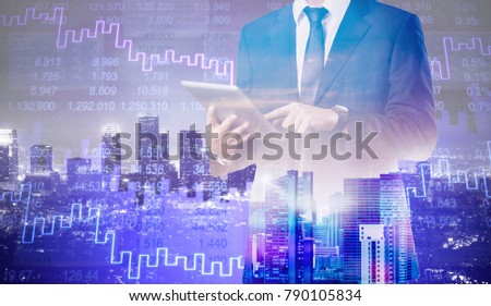 Double exposure of skyscraper and businessman with digital tablet