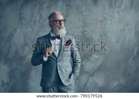 Portrait of proud respected confident handsome masculine virile vintage grey-haired sharp dressed in bespoke checkered grey suit with vinous handkerchief brutal macho isolated on concrete background Royalty-Free Stock Photo #790179526