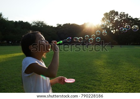 asian girl blowing  bubble in the sun light