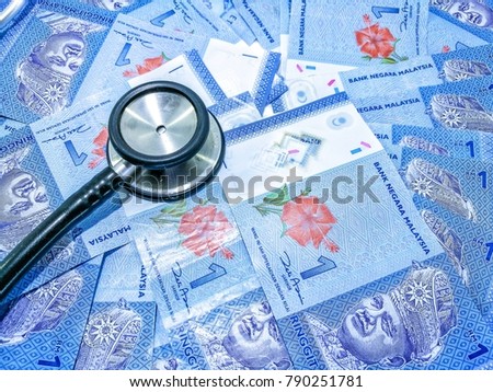 Stethoscope on money background : Malaysia Currency (MYR), one ringgit. Savings and healthcare concept.