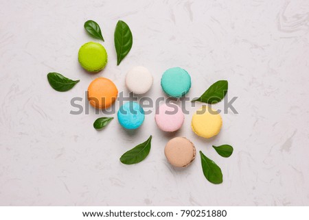 Spring concept with macaroons and green leaves. Top view