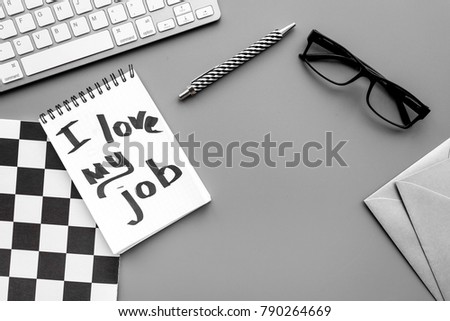 Find dream job. Handwritten motto I love my job in notebook on office desk on grey background top view copy space