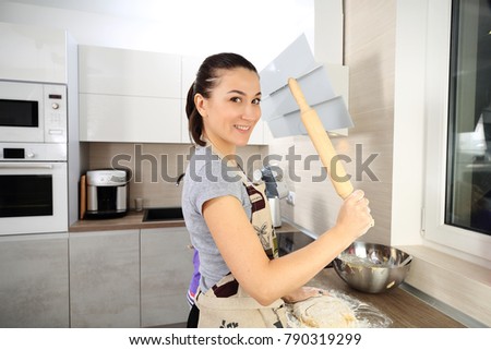 Girl with rolling pin studio shoot. Smiling white girl cooking at home.