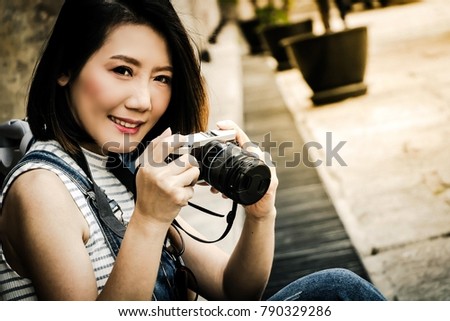 Portrait of beautiful young Asian traveler taking photo with camera in city. Japanese happy travel woman photography hipster lifestyle. Travel concept.