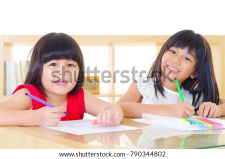 Asian kids drawing picture with color pencils