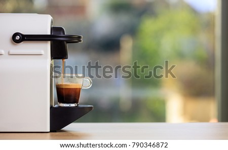 Morning capsule coffee. Espresso maker machine on a wooden table. Blurred background, space for text, front view Royalty-Free Stock Photo #790346872