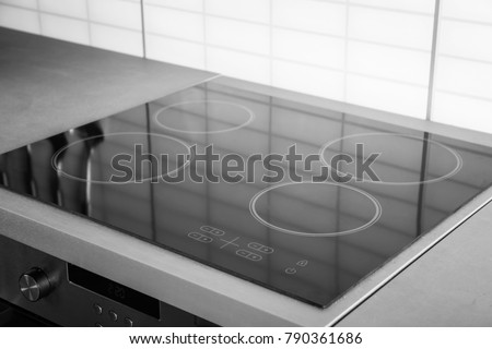 New electric stove with induction cooktop in kitchen, closeup Royalty-Free Stock Photo #790361686