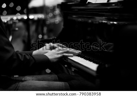 The hands of a musician playing the piano closeup in black and white tones
